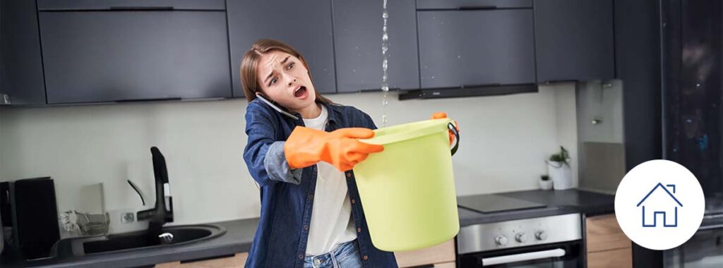 Homeowner inspecting a roof leak and contacting their insurance company
