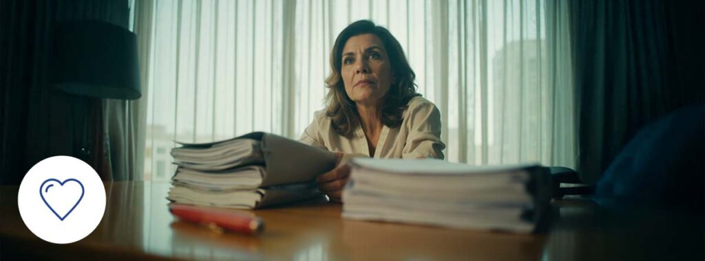 Hispanic woman comparing term and permanent life insurance policies in a modern office to choose the best coverage option.
