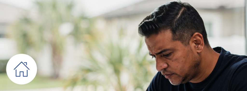 Latino homeowner reviewing insurance documents on a light table in Florida