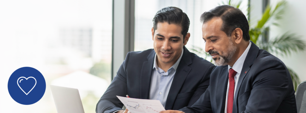 Latino business owners reviewing documents together in bright modern Florida office